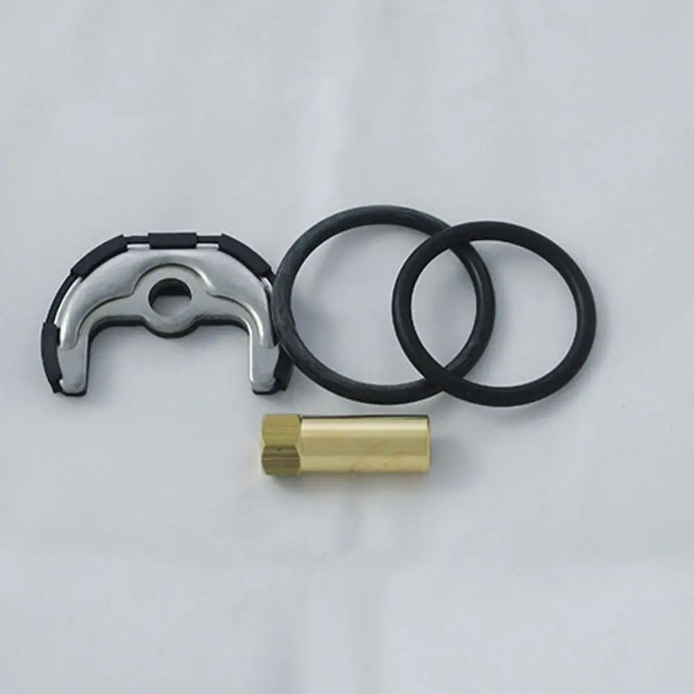 Befestigungssatz von Kludi, bestehend aus einer Metallklammer, zwei O-Ringen und einem goldfarbenen Einsatz. Gezeigt auf einer hellen Unterlage.